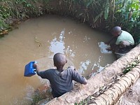 Children gathering contaminated water in the Wakiso District near Kamplala, Uganda