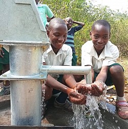 2 boys love the new well outside Kampala, Uganda