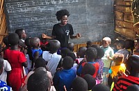 Teacher with children outside Kampala, Uganda