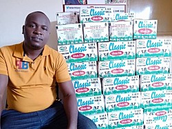 Tonny Mwesigwa with the milk he was able to buy, with your donations, for the needy children