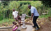 Applying the finishing touches to the newly installed well, near Kampala, Uganda, Africa
